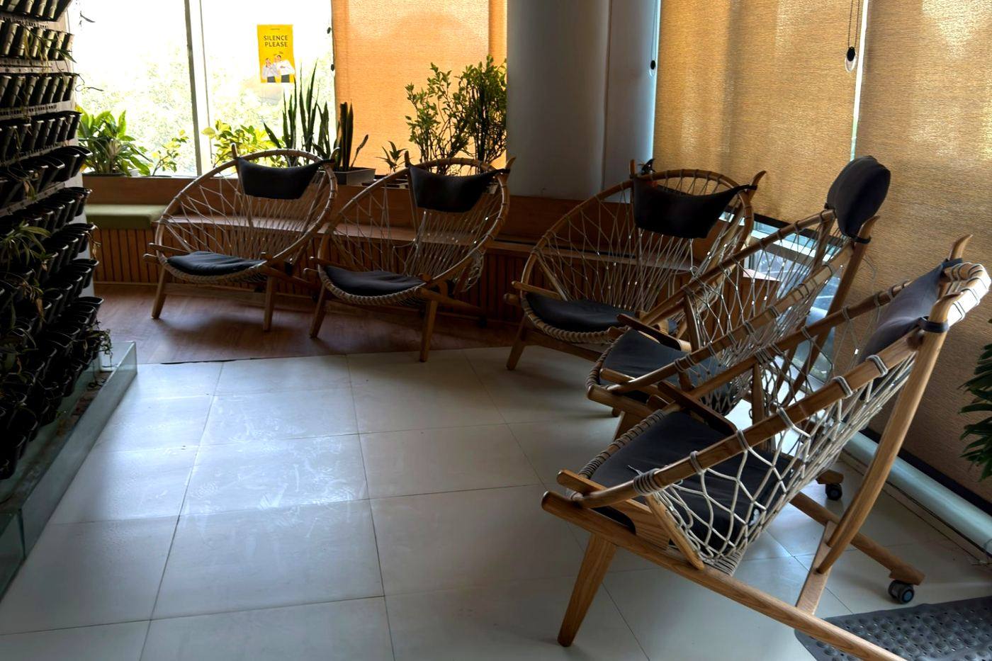 Breakout seating area with rattan chairs and a green wall